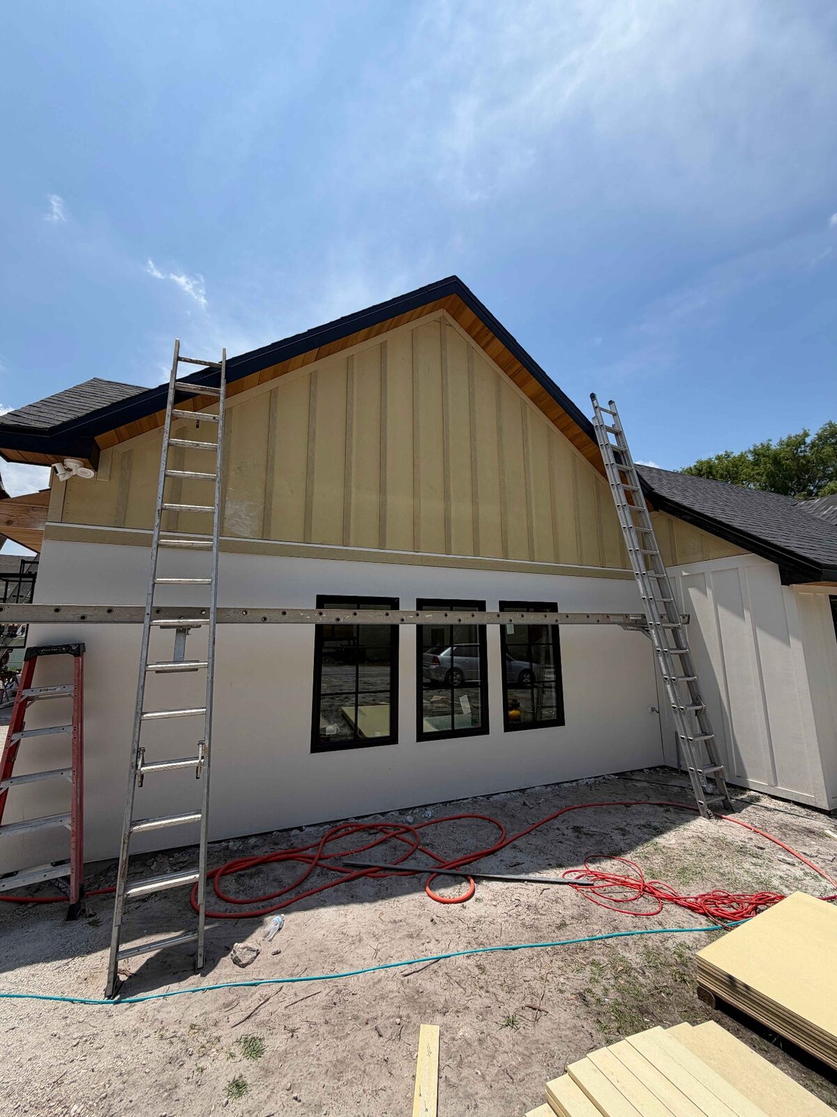 Board-and-batten siding on a tall gable with stained wood soffit and black fascia trim